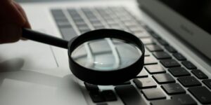 magnifying glass near gray laptop computer